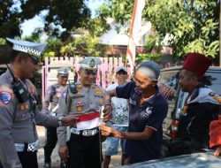 Jelang HUT RI, Satlantas Bondowoso Bagikan Bendera Merah Putih ke Pedagang dan Pengunjung Pasar Hewan